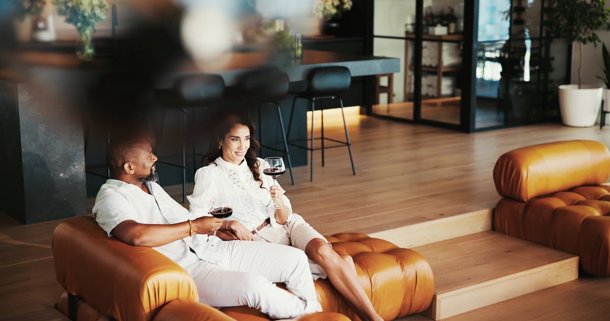 House, red wine and couple on sofa, relax and comfort